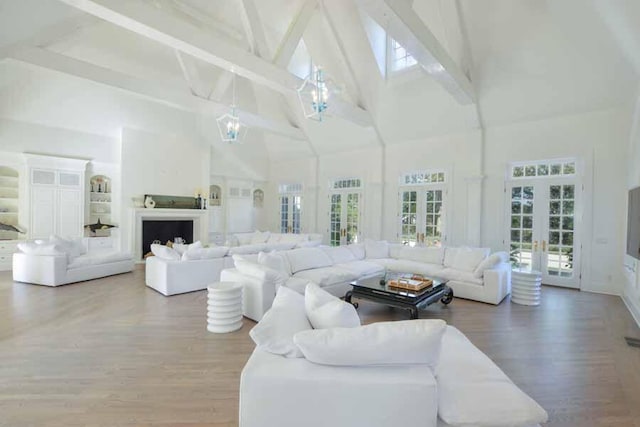 living room featuring beam ceiling, hardwood / wood-style floors, high vaulted ceiling, and french doors