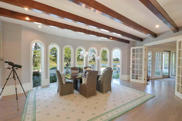 sunroom featuring beamed ceiling, french doors, and a healthy amount of sunlight