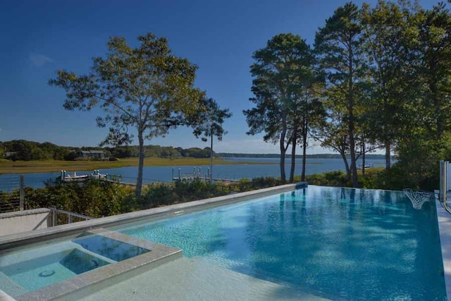 view of swimming pool with a water view and an in ground hot tub