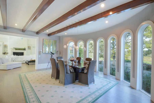 dining space with beamed ceiling and a healthy amount of sunlight