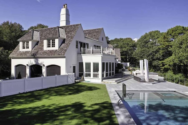 back of house featuring a balcony, a yard, a fenced in pool, a sunroom, and a patio area