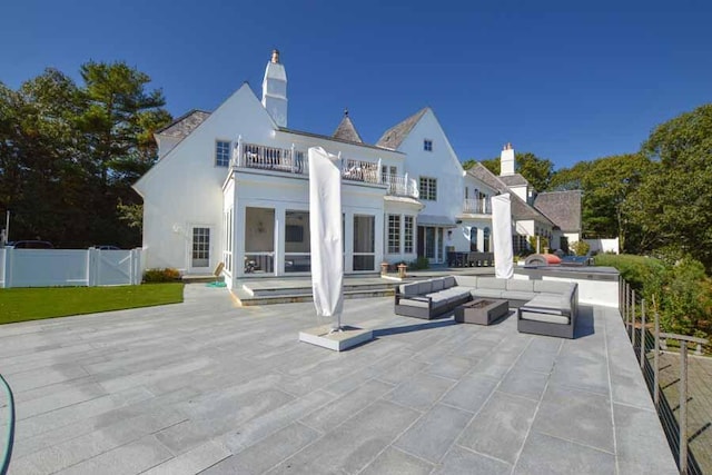 rear view of property featuring a patio area and a balcony