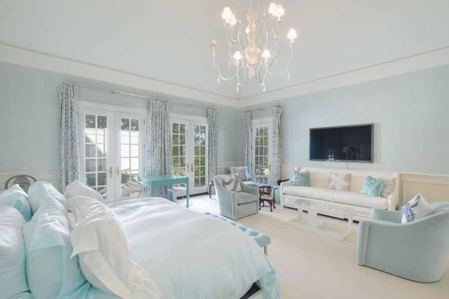 carpeted bedroom with french doors and a chandelier