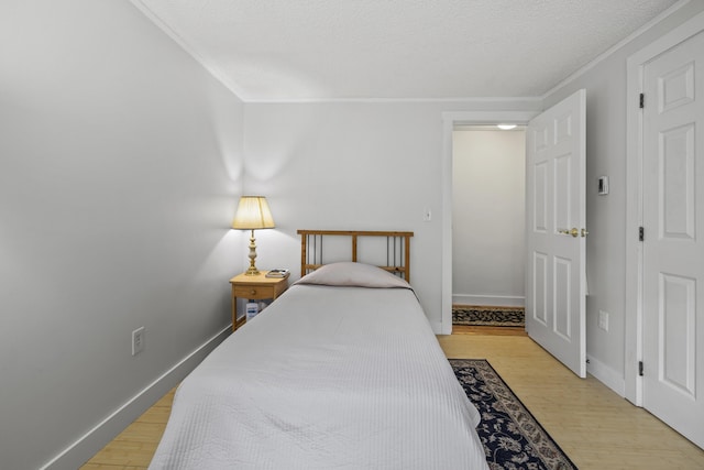 215 Head Of The Bay Rd, Buzzards Bay, MA 02532 - bedroom featuring crown molding, light wood-style floors, baseboards, and a textured ceiling