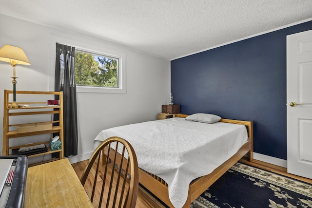 215 Head Of The Bay Rd, Buzzards Bay, MA 02532 - bedroom featuring a textured ceiling, wood finished floors, and ornamental molding