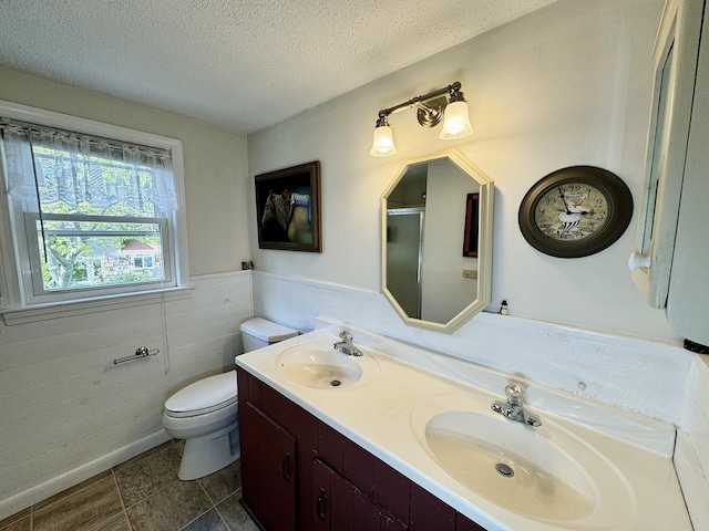 bathroom featuring toilet, a textured ceiling, an enclosed shower, and vanity