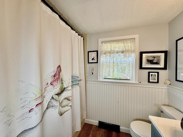 bathroom with toilet, hardwood / wood-style flooring, a textured ceiling, and vanity