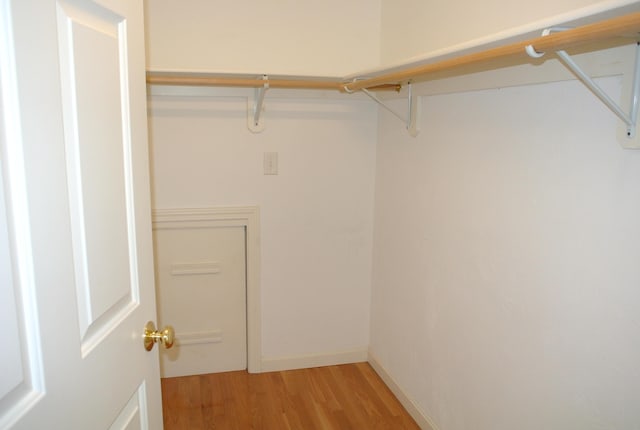 walk in closet with light hardwood / wood-style floors