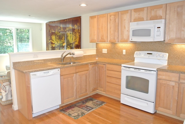 kitchen with backsplash, white appliances, light wood-type flooring, and light brown cabinetry