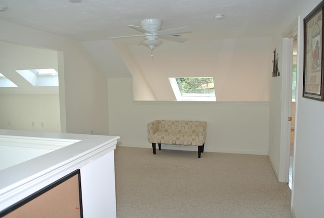 interior space with light carpet and vaulted ceiling with skylight