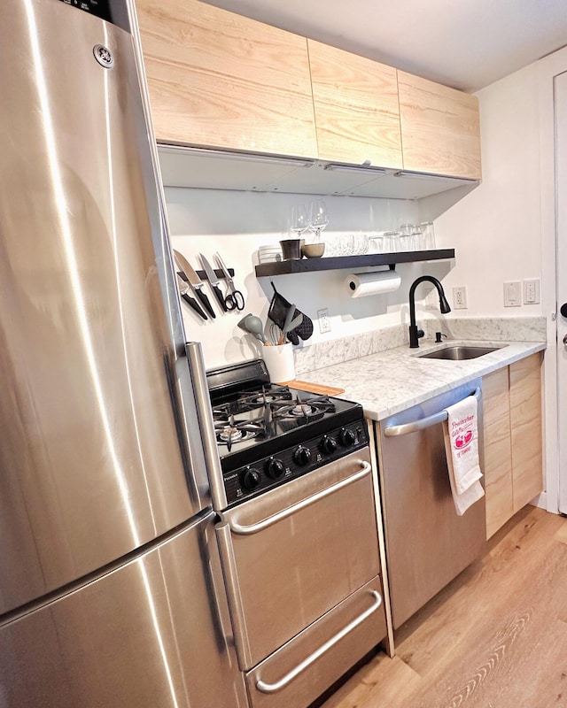 476 Commercial St Unit 4, Provincetown, MA 02657 - kitchen with appliances with stainless steel finishes, light wood-type flooring, light brown cabinets, and light stone counters