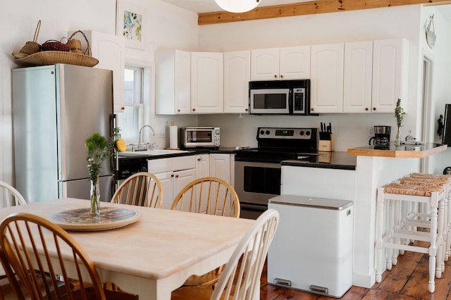 115 Rte 28, West Harwich, MA 02671 - kitchen with dark countertops, a toaster, appliances with stainless steel finishes, white cabinets, and a sink