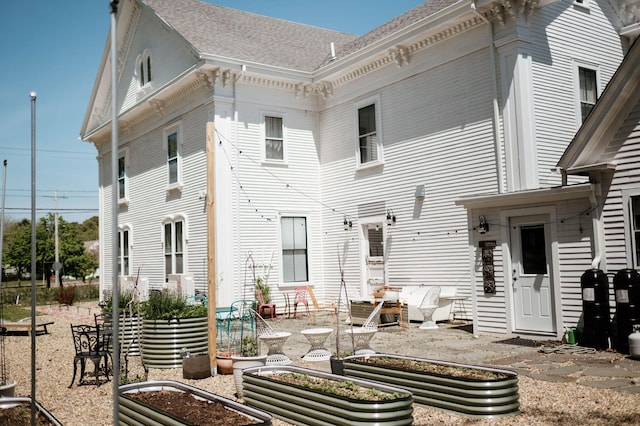 115 Rte 28, West Harwich, MA 02671 - rear view of house featuring a patio, a shingled roof, and a vegetable garden