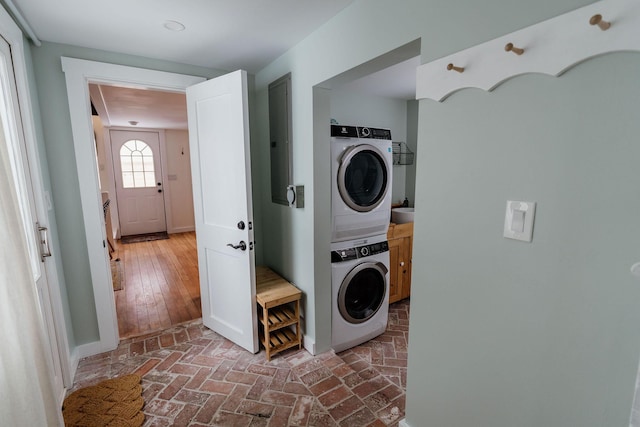 115 Rte 28, West Harwich, MA 02671 - laundry area featuring brick floor, baseboards, cabinet space, and stacked washer / dryer
