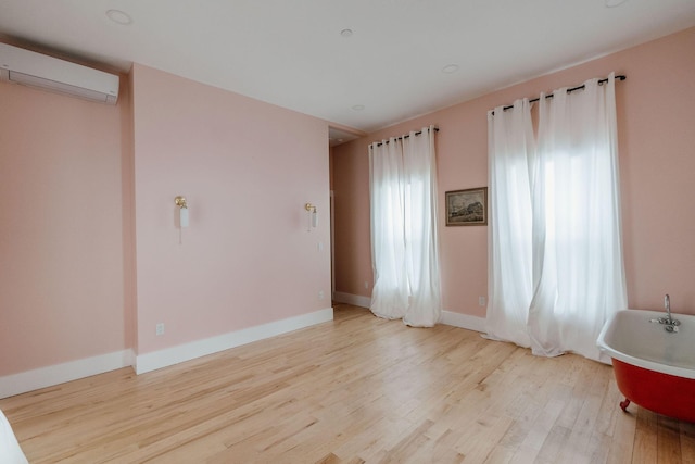 115 Rte 28, West Harwich, MA 02671 - empty room with a wall unit AC, baseboards, and light wood-type flooring