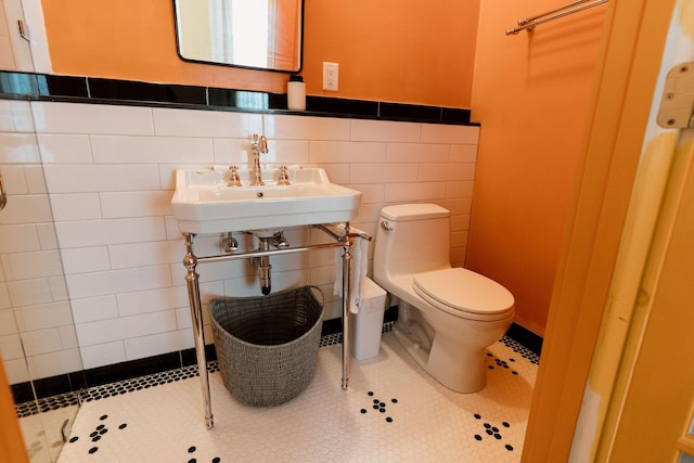 115 Rte 28, West Harwich, MA 02671 - bathroom featuring tile patterned flooring, toilet, wainscoting, tile walls, and a sink