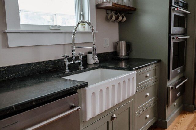 115 Rte 28, West Harwich, MA 02671 - kitchen featuring open shelves, a sink, appliances with stainless steel finishes, dark countertops, and a warming drawer
