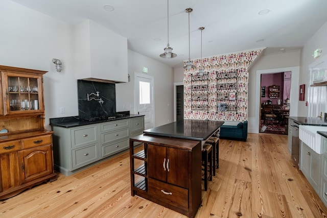 115 Rte 28, West Harwich, MA 02671 - kitchen featuring decorative backsplash, glass insert cabinets, light wood-style floors, pendant lighting, and dark countertops