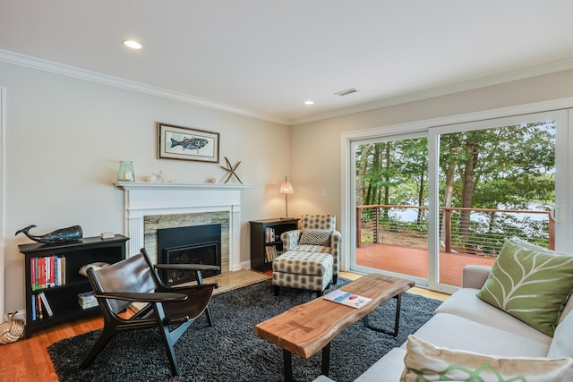 living room featuring ornamental molding, a fireplace, wood finished floors, and recessed lighting