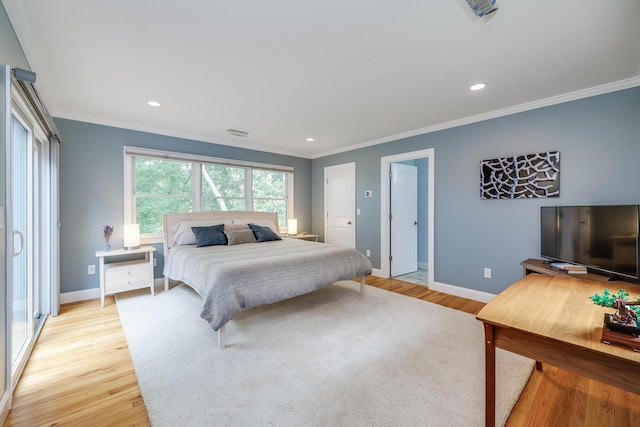 bedroom featuring ornamental molding, light wood-type flooring, visible vents, and baseboards