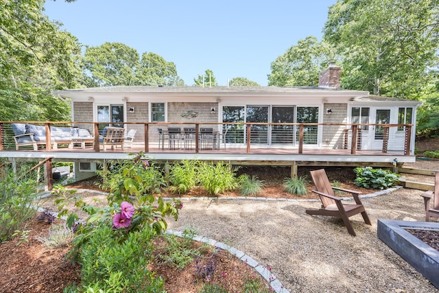 rear view of property featuring a chimney and a deck