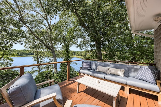 wooden terrace featuring a water view and an outdoor living space