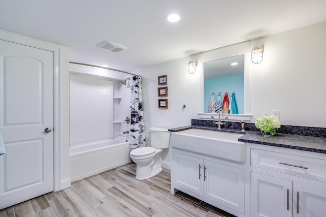 full bathroom with visible vents, shower / bathtub combination with curtain, toilet, vanity, and wood finished floors