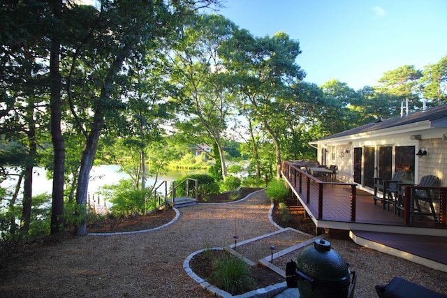 view of yard with a deck with water view