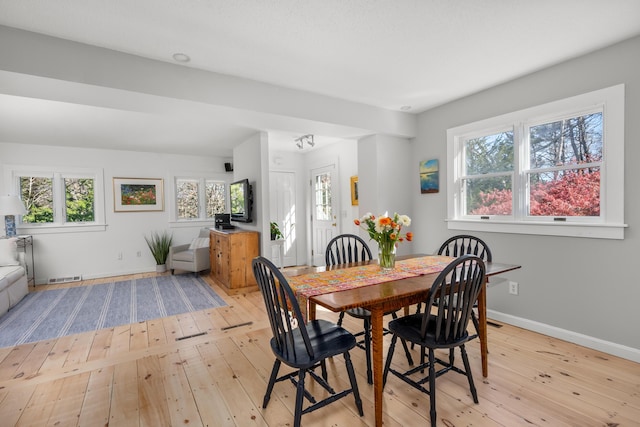 dining space with light wood-style flooring, plenty of natural light, and baseboards