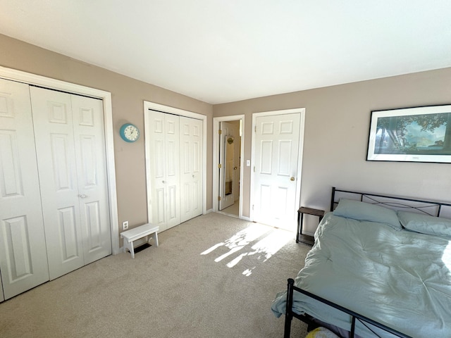 bedroom featuring multiple closets and carpet