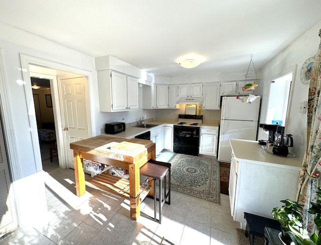 kitchen with sink, white cabinets, range with electric stovetop, and white fridge