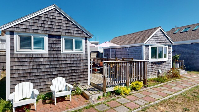 rear view of house featuring a wooden deck