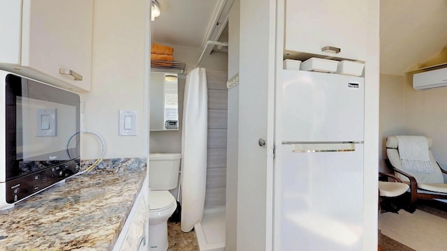 bathroom featuring a wall mounted air conditioner, toilet, vanity, and a shower with shower curtain