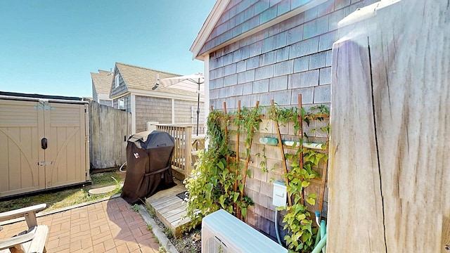 view of patio with ac unit and a storage shed