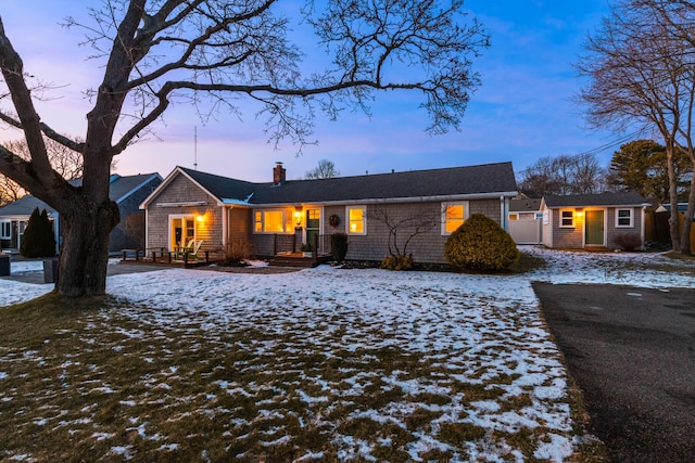 view of front of home featuring an outdoor structure, a chimney, and fence