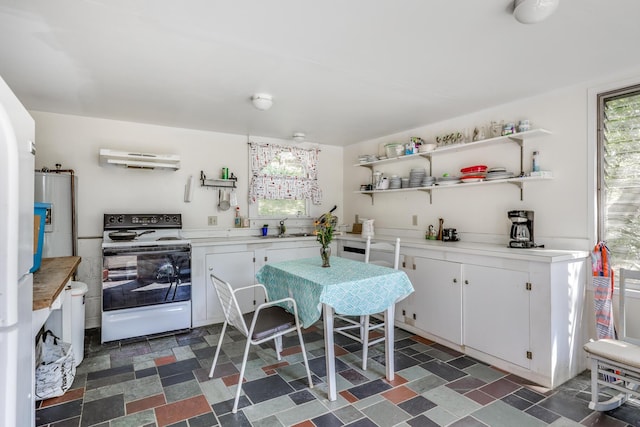 kitchen featuring white range with electric cooktop, white cabinets, and sink