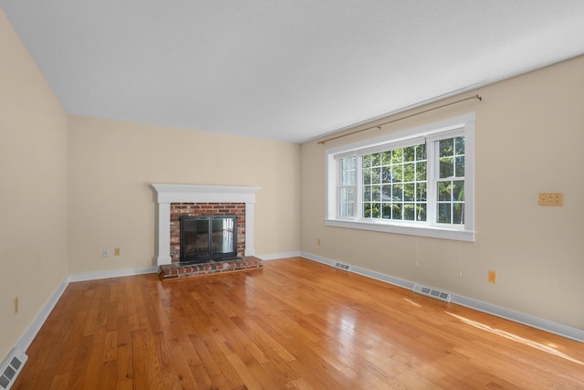 unfurnished living room with a fireplace and light hardwood / wood-style floors