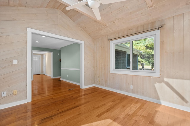 empty room with wood ceiling, vaulted ceiling with beams, wooden walls, and wood-type flooring