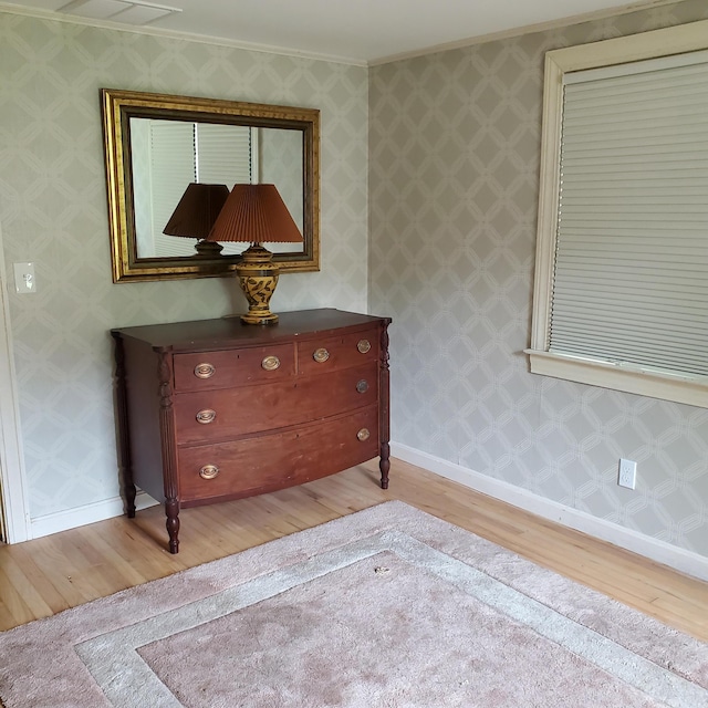 interior space featuring light wood-type flooring and ornamental molding