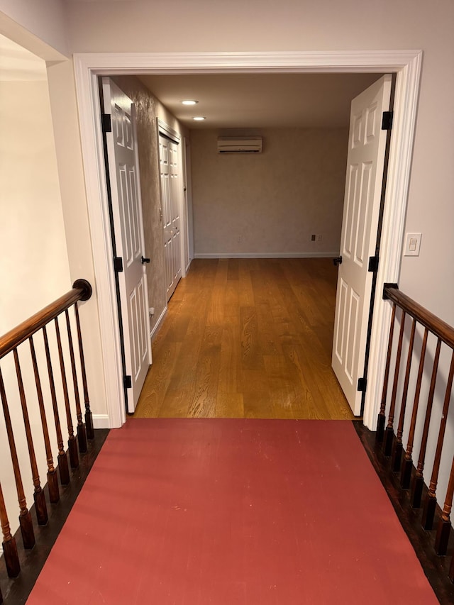 corridor featuring an AC wall unit and dark wood-type flooring