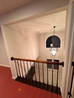 stairs with a notable chandelier