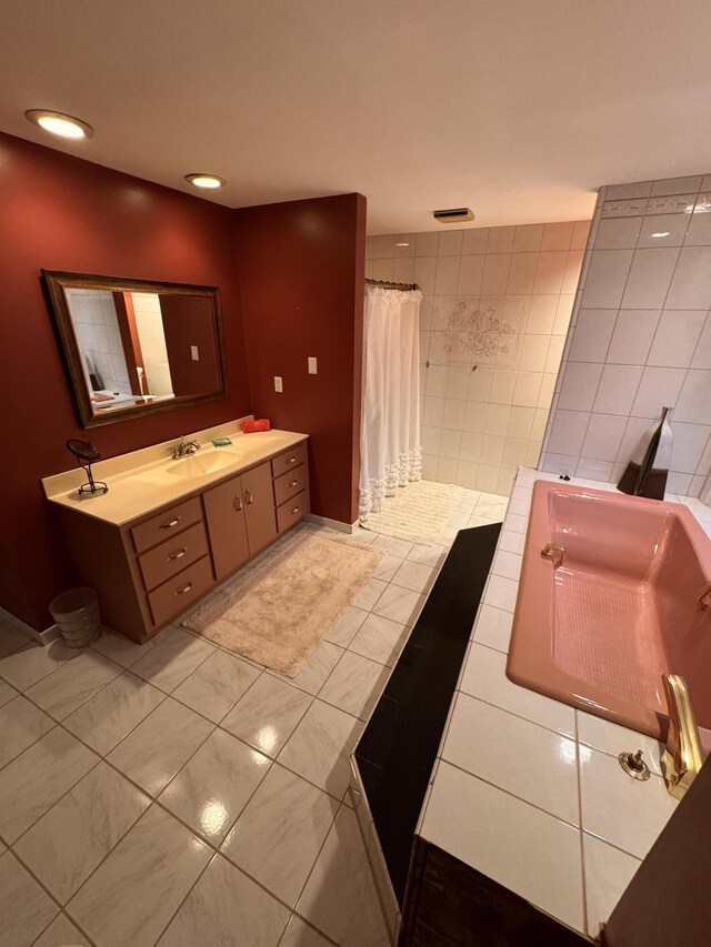 bathroom with vanity, tile patterned floors, curtained shower, and tile walls