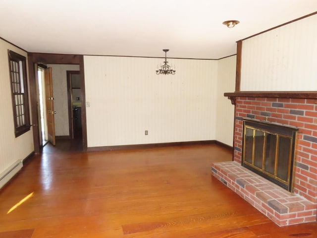unfurnished living room with baseboard heating, baseboards, a fireplace, and wood finished floors