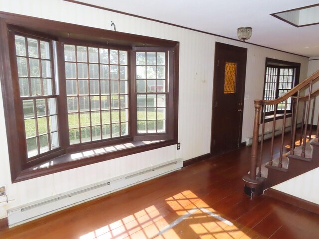 foyer featuring baseboards, stairs, wood finished floors, and baseboard heating