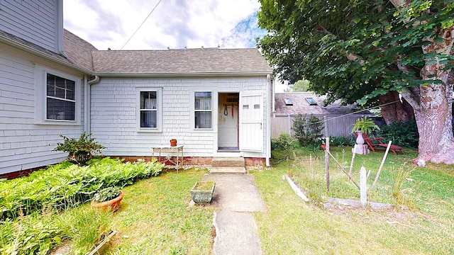 entrance to property featuring a lawn