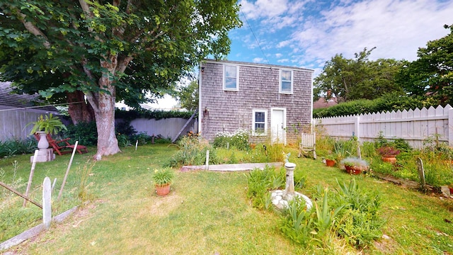 rear view of house featuring a yard