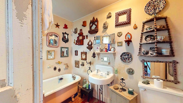 bathroom featuring sink, toilet, and a bath