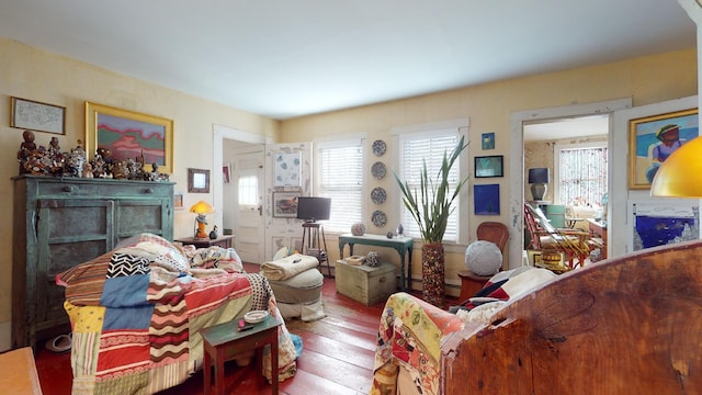 living room featuring baseboard heating, wood-type flooring, and a wealth of natural light