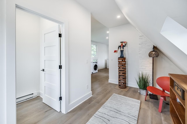 36 Pearl St Unit 3, Provincetown, MA 02657 - living area with washer / clothes dryer, baseboard heating, wood finished floors, lofted ceiling, and a skylight