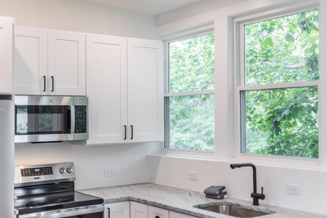 36 Pearl St Unit 3, Provincetown, MA 02657 - kitchen with stainless steel appliances, a sink, white cabinetry, and light stone countertops